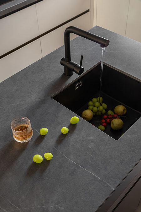 Sintered stone countertop and backsplash around a modern kitchen sink
