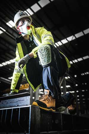 A worker wearing ladder grip shoes at a high place