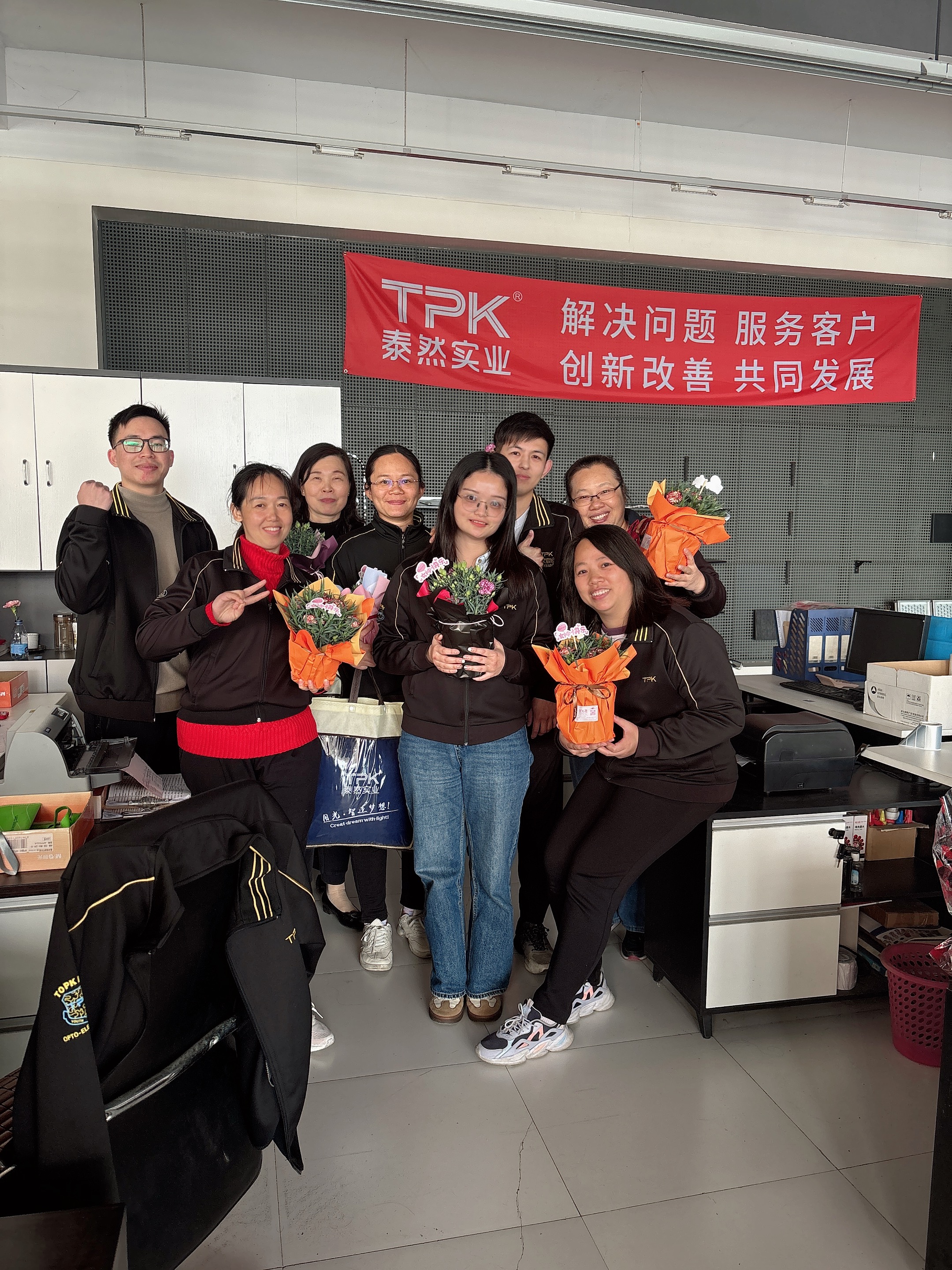 Female employees with flowers - vertical