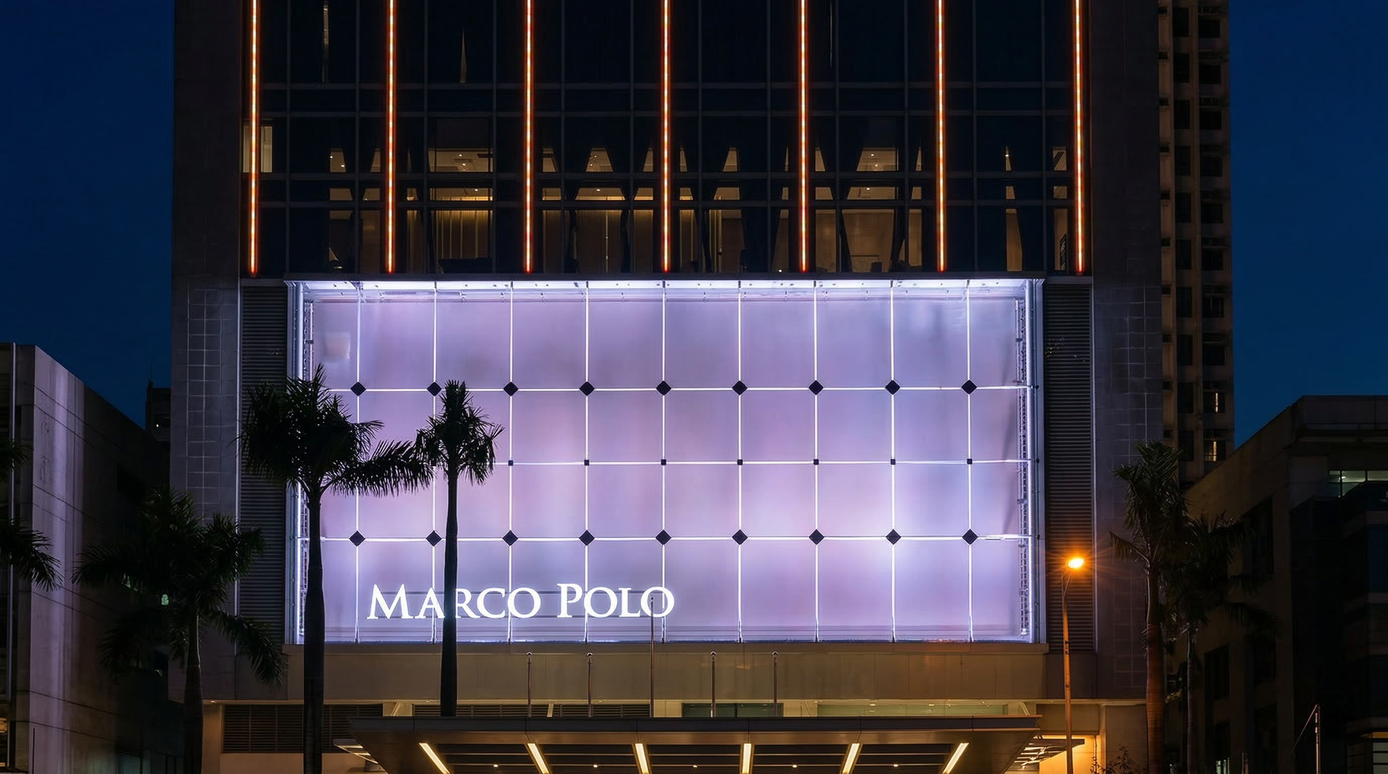 DMX-controlled RGBW LED wall washers illuminating vertical building silhouette