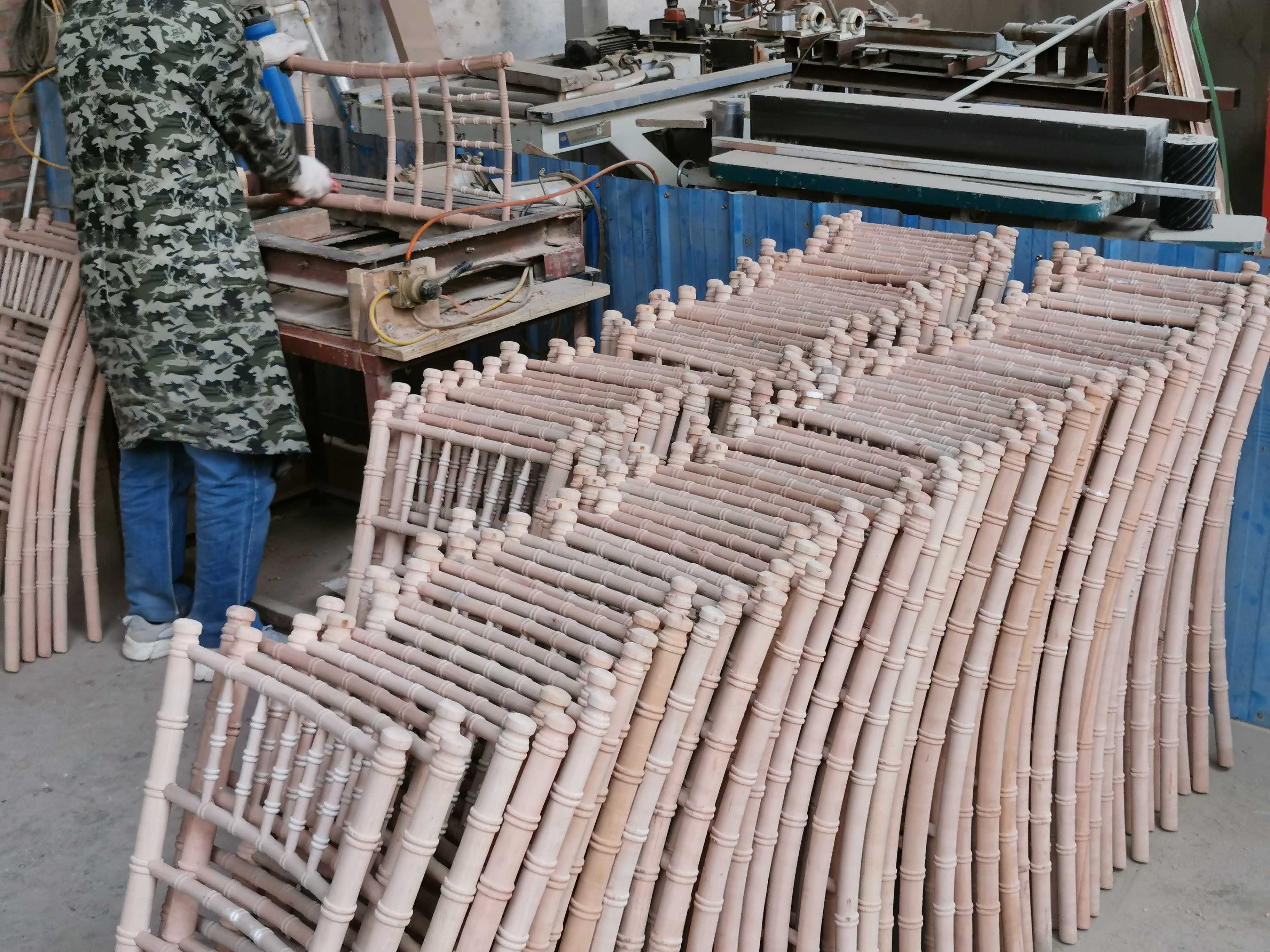 The worker is producing chiavari chairs.